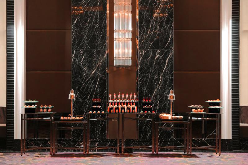 Refreshment station set against a black marble wall