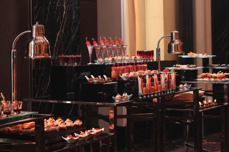 Buffet spread of canapés, desserts and drinks on mirrored stands